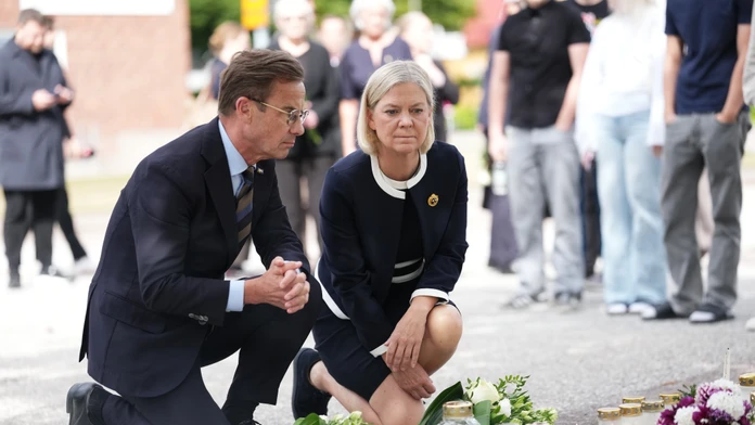 Na snímke švédsky premiér Ulf Kristersson (vľavo) a líderka Sociálnodemokratickej strany Magdalena Anderssonová kladú kvety k provizórnemu pamätníku pred strednou školou Brinell deň po útoku.