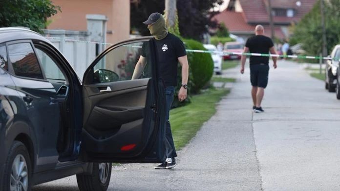 Policajt pri dome zavraždeného novinára. 
