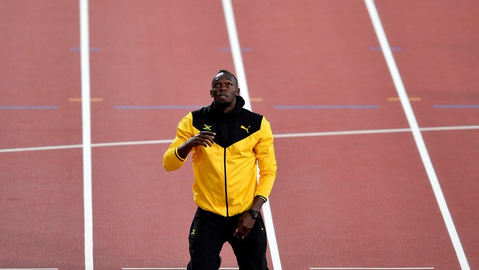 Jamajský šprintér Usain Bolt kľačí na kolenách na cieľovej čiare  jeho symbolického posledného čestného okruhu na záver MS.