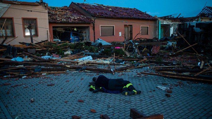 Vyčerpaný hasič leží na zemi.
