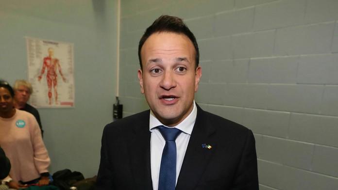 Ľudia zapaľujú sviečky a pokladajú kvety pred obchodom v Hanau, kde došlo k streľbe.