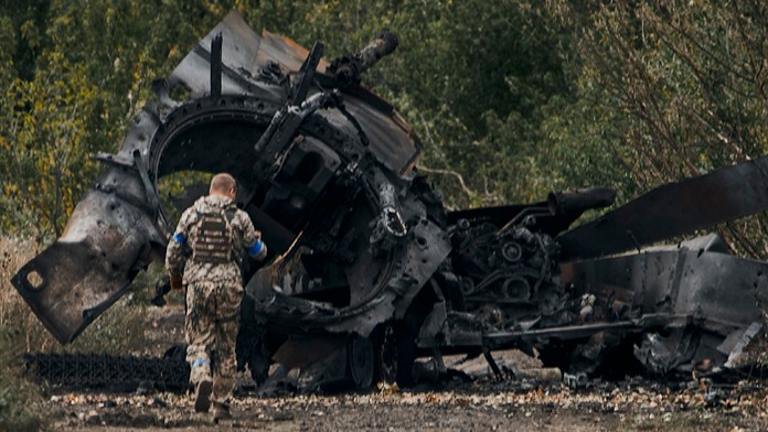 Ukrajinský vojak prechádza okolo ruského tanku poškodeného v boji.