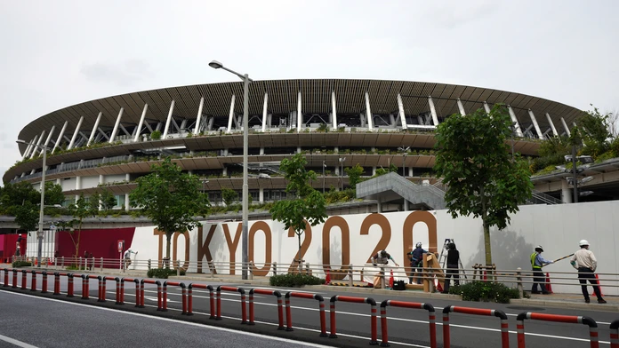 Zamestnanci natierajú oplotenie Národného štadióna, kde sa uskutoční otvárací ceremoniál a ďalšie podujatia olympijských hier.