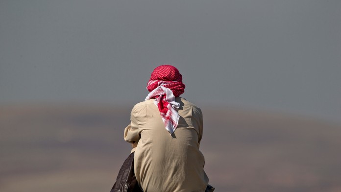 Muž sleduje z kopca boje pri Kobani, blízko hranice medzi Tureckom a Sýriou. 24. októbra