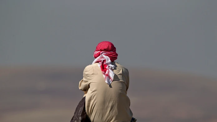 Muž sleduje z kopca boje pri Kobani, blízko hranice medzi Tureckom a Sýriou. 24. októbra