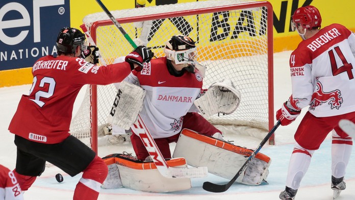 Na snímke vľavo Švajčiar Nino Niederreiter strieľa gól v predĺžení dánskemu brankárovi Sebastianovi Dahmovi v zápase A-skupiny M