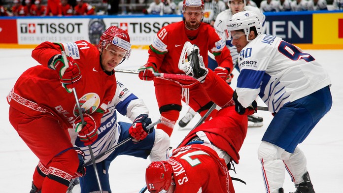 Francúzsky hokejista Maxime Moisand (vpravo) a Bielorusi Sergej Kosticyn (uprostred) a Alexander Pavlovič bojujú o puk počas MS 