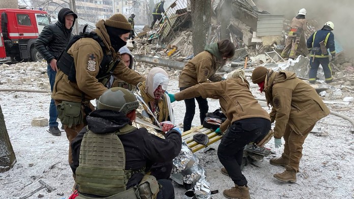 Príslušníci záchranných zložiek ošetrujú zraneného miestneho obyvateľa po ruskom raketovom útoku na Charkov.