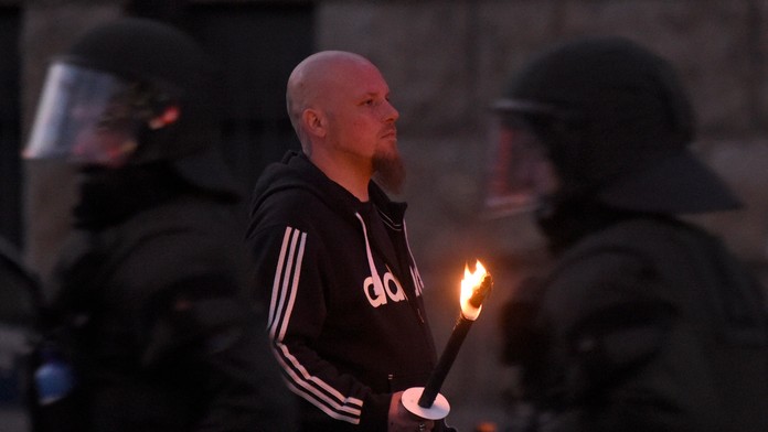 Krajne pravicový demonštrant drží pochodeň.