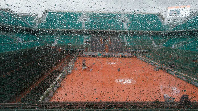 Centrálny kurt vidieť cez sklo počas dažďa pred začiatkom zápasov 1. kola na grandslamovom turnaji Roland Garros. 