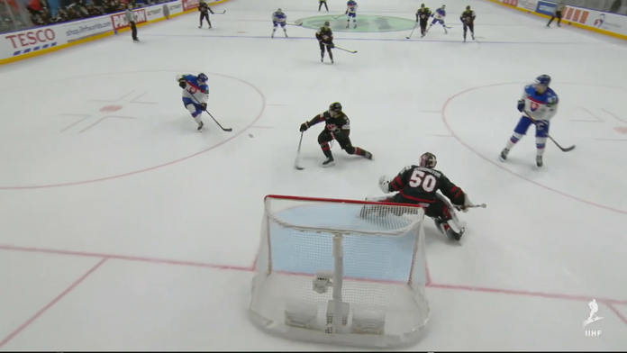 Miloš Kelemen strieľa do prázdnej bránky puk, gólu zabránil kanadský hokejista