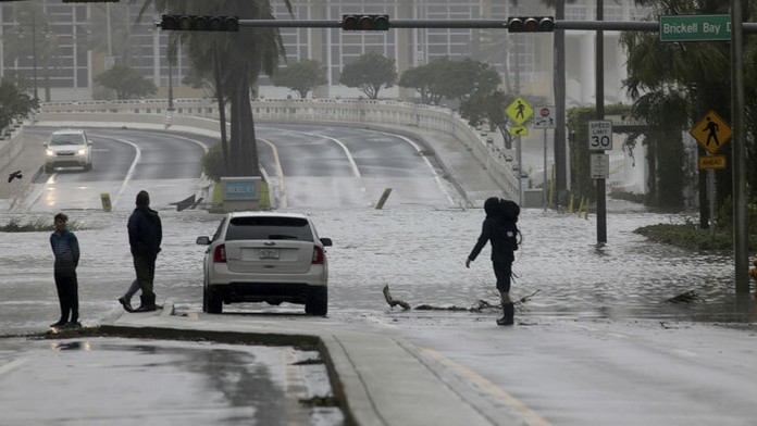 Ľudia na zaplavenej Brickell Avenue v Miami