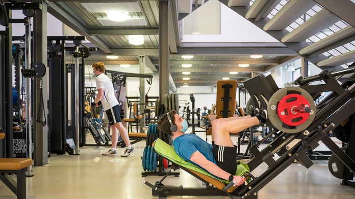 Ľudia cvičia v znovuotvorenom fitnescentre v nemeckom meste Saarbrücken.