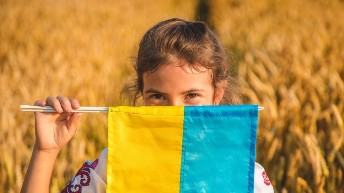 Dieťa drží v ruke ukrajinskú vlajku.