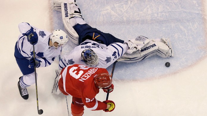 Brankár Toronta Maple James Reimer sleduje puk pred Johanom Franzenom 