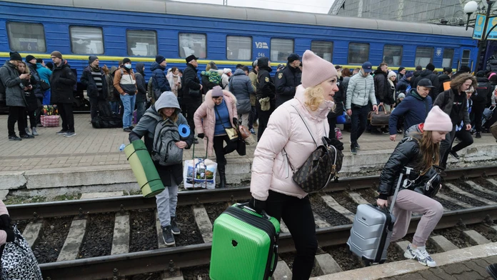 Z Kyjeva sa snažia utiecť tisícky ľudí. Na vlak idú pešo a keď zaznejú sirény, bežia sa schovať