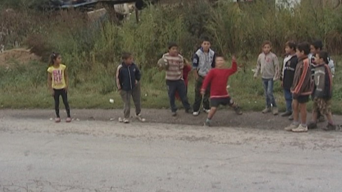 Deti hádžu kamene do áut. 