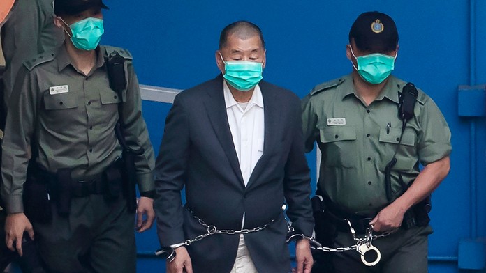 Jimmyho Laia privádzajú policajti v putách na súd v Hongkongu.