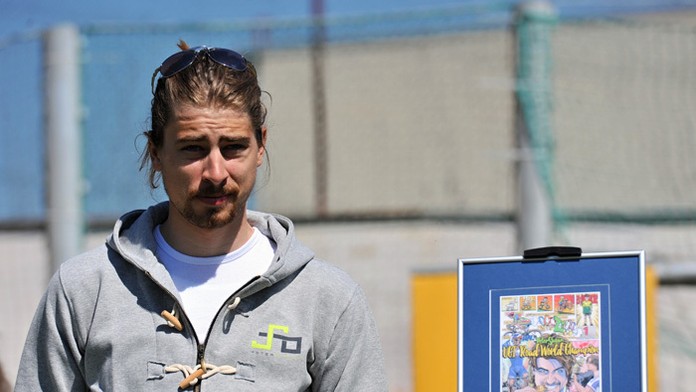 Majster sveta v cestnej cyklistike Peter Sagan pózuje pri nálepnom liste s novou známkou a obálkou s pečiatkou.