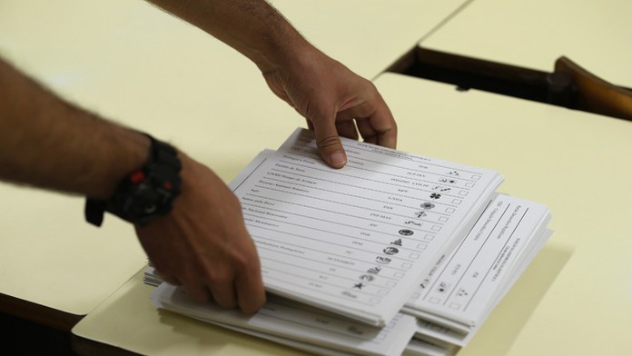 Členka volebnej komisie pripravuje hlasovacie lístky počas hlasovania v parlamentných voľbách v Massame pri Lisabone. 
