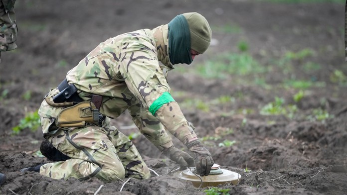 Na archívnej snímke z 19. apríla 2022  ženista ministerstva vnútra zneškodňuje mínu na mínovom poli po nedávnych bojoch v meste Irpiň neďaleko Kyjeva.