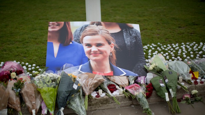 Kvety na znak úcty pri obrázku zabitej britskej labouristickej poslankyne Jo Coxovej neďaleko parlamentu v Londýne..