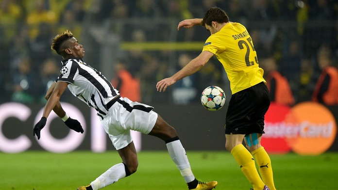 Hráč Juventusu Paul Pogba a vpravo hráč Dortmundu Sokratis Papastathopoulos v semifinále Ligy majstrov Borussia Dortmund - Juven