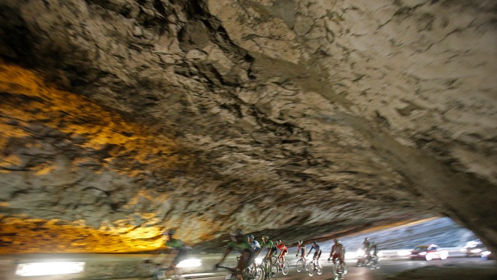 Pelotón prechádza prírodným tunelom na trase 17. etapy.