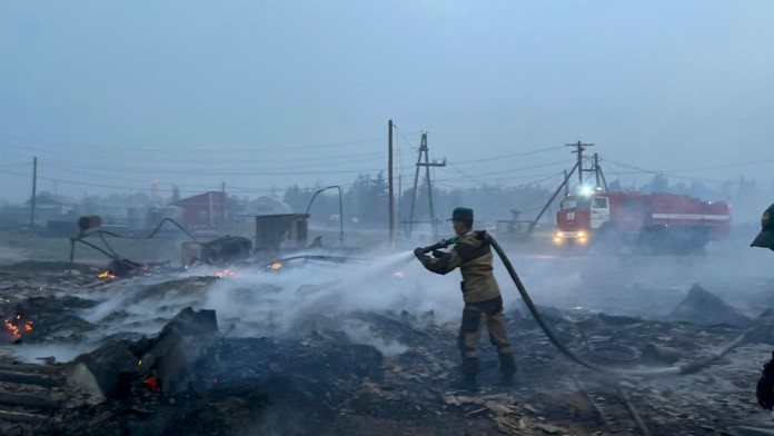 Hasič bojuje s ohňom v ruskej obci Byas-Kuel.