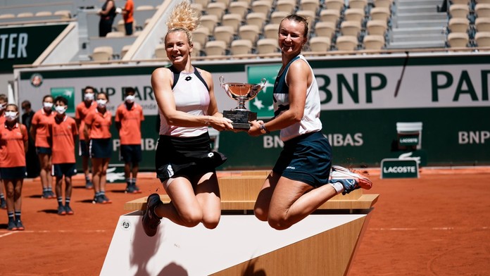 Český deblový pár Barbora Krejčíková (vpravo) a Kateřina Siniaková skáču s trofejou po výhre.