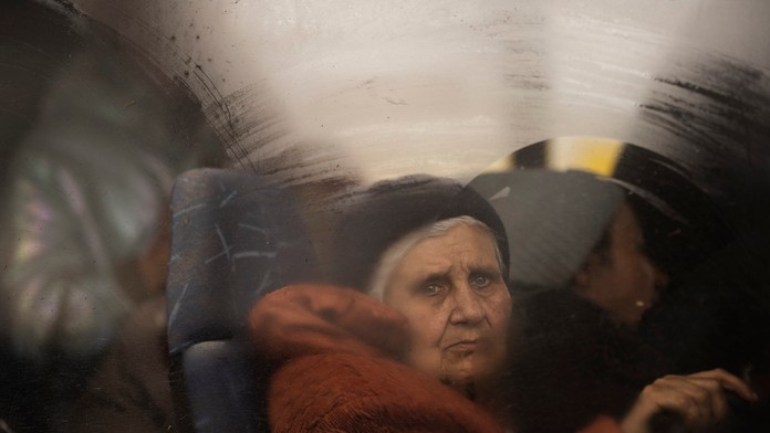 Záber staršej ženy v autobuse v Mariupole.