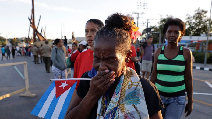Plačúca žena čaká na auto s truhlou Fidela Castra.