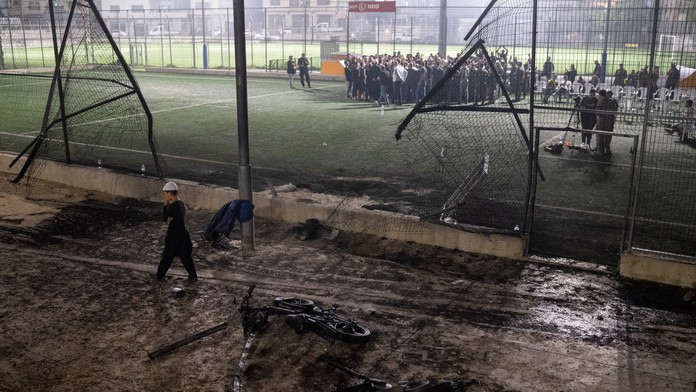 Chlapec kráča okolo bicyklov položených neďaleko futbalového ihriska, ktoré zasiahla raketa v meste Madždal Šams.