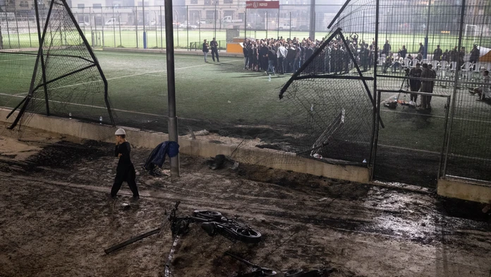 Chlapec kráča okolo bicyklov položených neďaleko futbalového ihriska, ktoré zasiahla raketa v meste Madždal Šams.