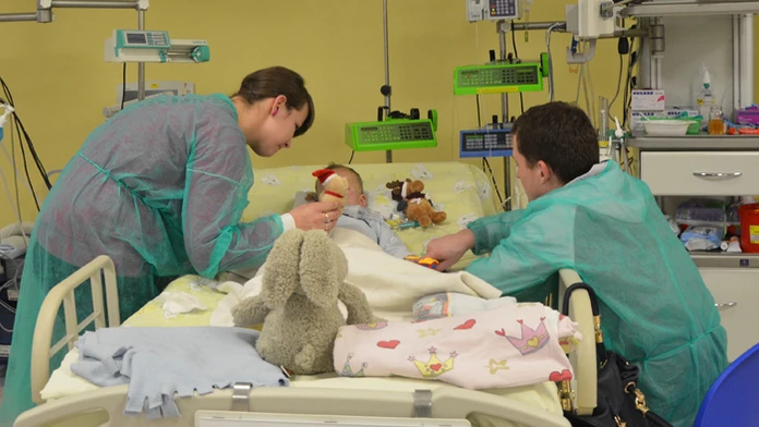 Mama Paulina a otec Mateusz sa skláňajú nad svojím dvojročným synom Adamom v nemocničnej izbe v detskej nemocnici v Krakove.