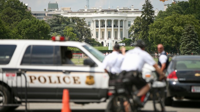 Policajti hliadkujú pred Bielym domom. 