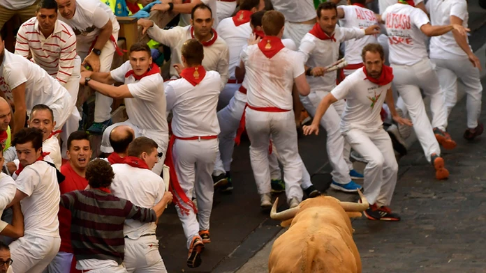 Muži bežia pred býkmi v úzkych uličkách počas prvého behu na tradičnom festivale San Fermíno v meste Pamplona.