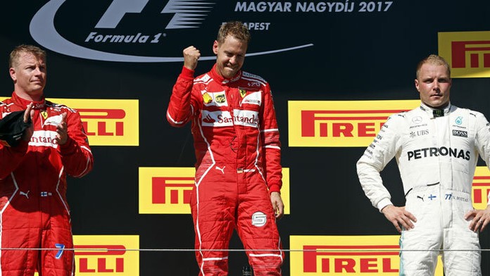 Nemecký pilot F1 zo stajne Ferrari Sebastian Vettel (v strede).