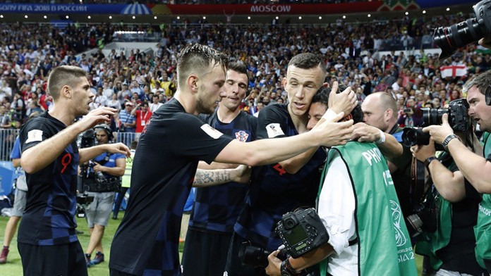 Chorvátski futbalisti utešujú fotografa, ktorého v eufórii zvalili po víťaznom góle na zem.