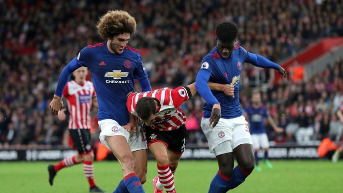 Cédrica Soaresa (v strede) zo Southamptonu atakuje v dueli PL dvojica z ManUtd Marouane Fellaini (vľavo) a Eric Bailly.