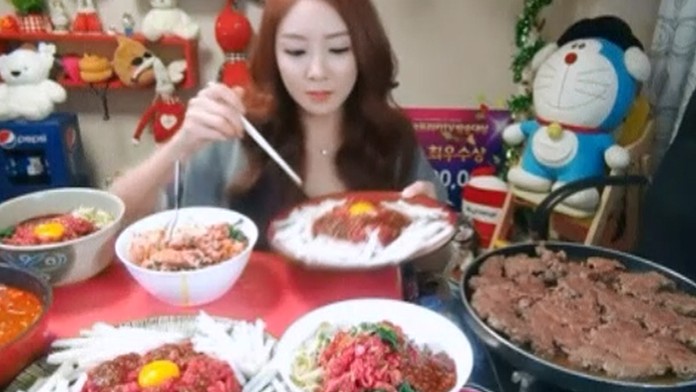 Žena jedáva pred kamerami, dostáva za to peniaze. 