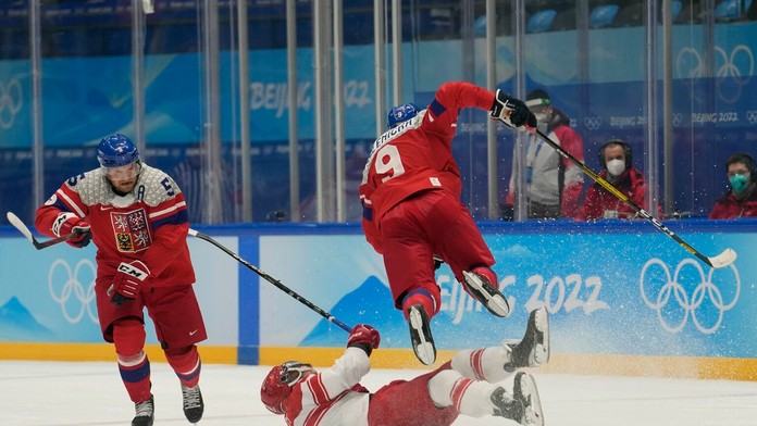 Český hokejista David Sklenička padá cez dánskeho hokejistu Frederika Storma.