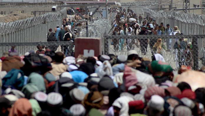 Ľudia, ktorí opustili svoje domovy  prechádzajú cez hranicu.