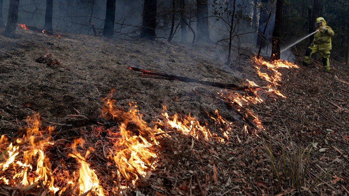 Hasič sa snaží uhasiť oheň.
