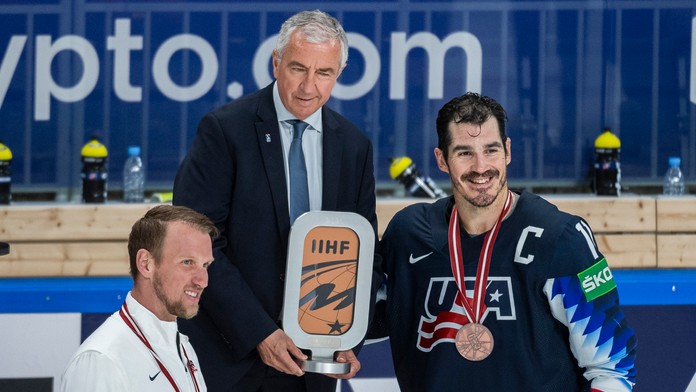 Prezident IIHF Luc Tardif odovzdáva ocenenie hráčom USA.