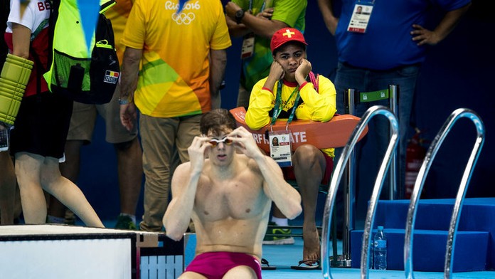 Unudená plavčíčka sedí a pozerá na olympijský bazén.