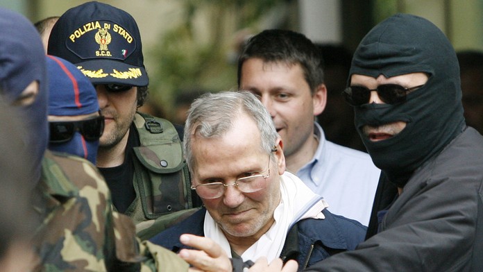 Na archívnej snímke z 11. apríla 2006 kukláči privážajú  Bernarda Provenzana na policajnú stanicu v Palerme