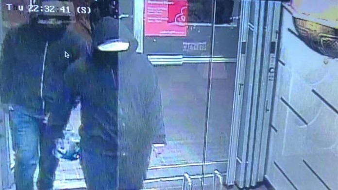 Polícia zverejnila fotografiu dvoch ľudí v tmavých mikinách, ako vchádzajú do objektu.