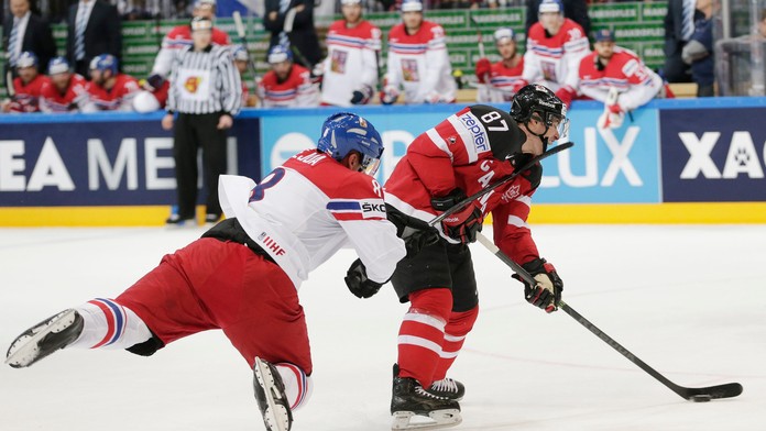 Kanadský hráč Sidney Crosby (vpravo) dostáva úder hokejkou do tváre od Čecha Jana Hejdu