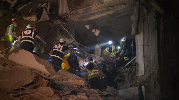 Záchranári odnášajú zraneného muža z budovy, ktorá bola zasiahnutá počas izraelského leteckého útoku v Bejrúte.